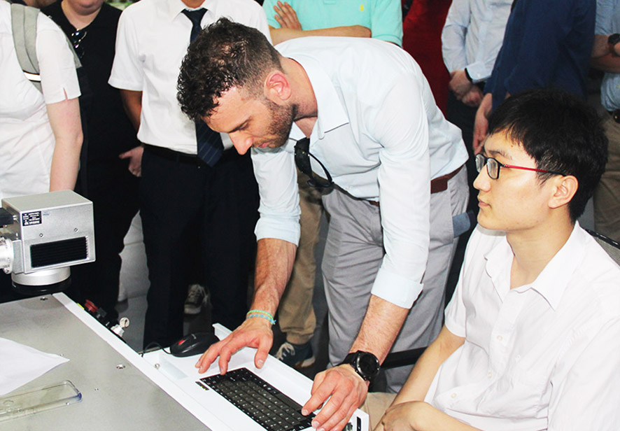 英國愛丁堡龍比亞大學的學生在大族粵銘集團激光應用工藝工程師的指導下下操作設備